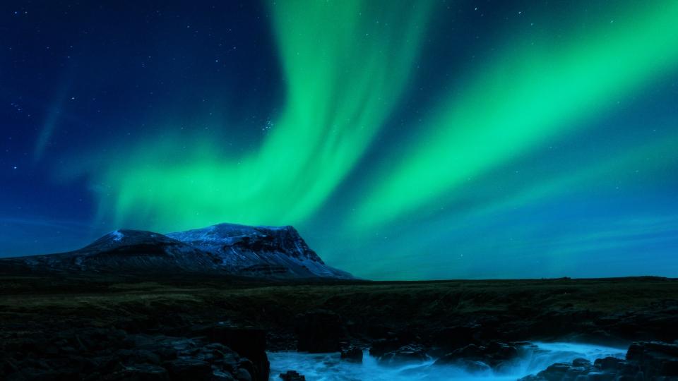  bright green auroras in the sky above a coastal scene in iceland 