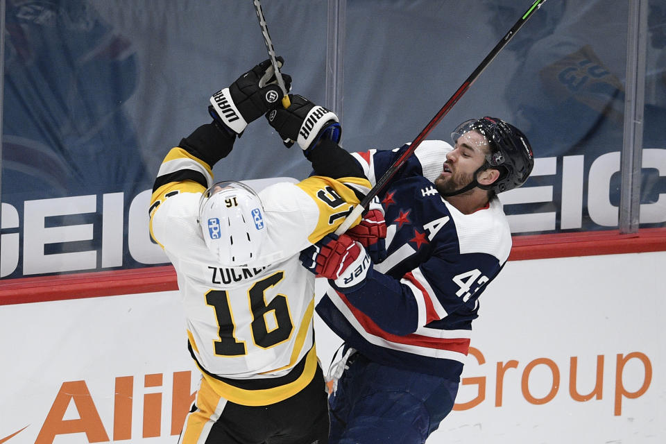 Washington Capitals right wing Tom Wilson (43) and Pittsburgh Penguins left wing Jason Zucker (16) collide during the first period of an NHL hockey game Saturday, May 1, 2021, in Washington. (AP Photo/Nick Wass)