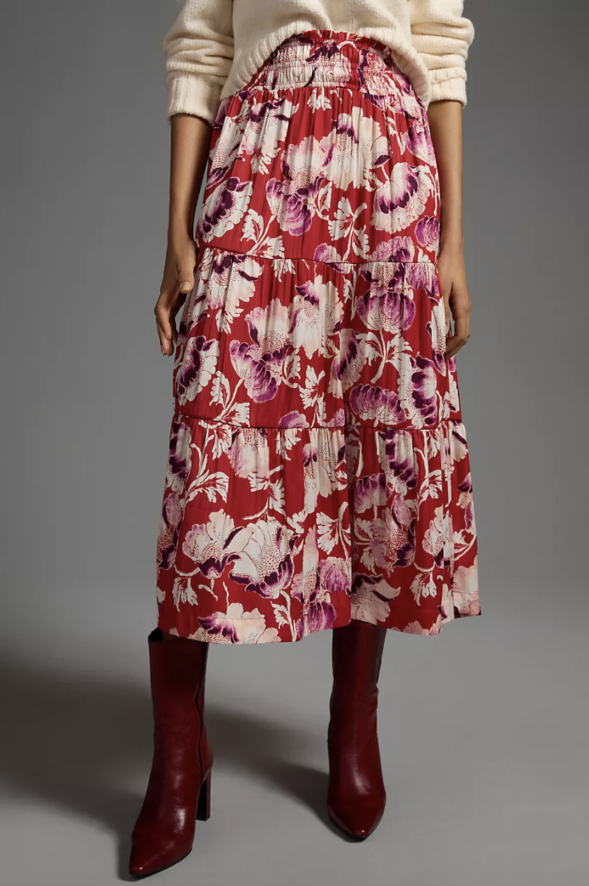 model wearing red boots and white sweater with red and pink floral The Somerset Maxi Skirt in red motif (photo via Anthropologie)