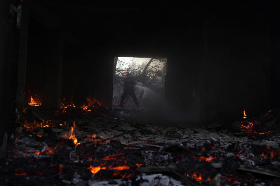 FILE - A firefighter tries to extinguish a fire at a house near Megara town, west of Athens, Greece, July 20, 2022. Major wildfires in Europe are starting earlier in the year, becoming more frequent, doing more damage and getting harder to stop. And, scientists say, they’re probably going to get worse as climate change intensifies unless countermeasures are taken. (AP Photo/Petros Giannakouris, File)