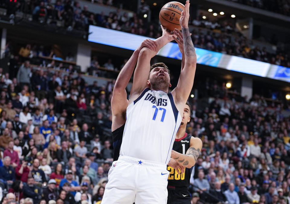 Dallas Mavericks guard Luka Doncic (77) shoots against the Denver Nuggets during the first quarter of an NBA basketball game Monday, Dec. 18, 2023, in Denver. (AP Photo/Jack Dempsey)