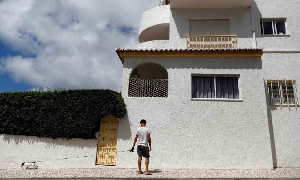 A man walks with his dog below the apartment where three-year-old Madeleine McCann disappeared in 2007, in Praia da Luz, Portugal.