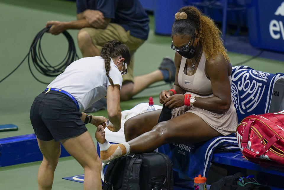 Serena Williams recibe atención de una kinesióloga durante la semifinal del Abierto de Estados Unidos ante la bielorrusa Victoria Azarenka, el jueves 10 de septiembre de 2020, en Nueva York (AP Foto/Seth Wenig)