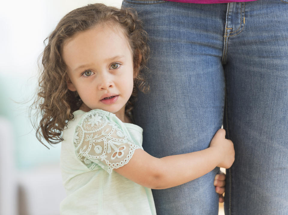 kid holding on to a parent's leg