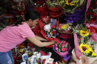 Shop owner Mary Jane Villegas arranges a Valentines flower arrangement which they called "anti-nCoV bouquet" in Alabang, metropolitan Manila, Philippines Thursday, Feb. 13, 2020. Villegas said she placed protective face masks, alcohol, soap, toothpaste and gloves in her bouquet to remind people that flowers are not the only things you can give during Valentines but also protection against the COVID-19. The "anti-nCoV" bouquet is sold for P1,300 or U.S. $26. (AP Photo/Aaron Favila)