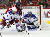 New York Rangers defenseman Dan Girardi (5) goes for the puck against Washington Capitals right wing Joel Ward (42) with goalie Henrik Lundqvist (30), from Sweden, during the first period of Game 6 in the second round of the NHL Stanley Cup hockey playoffs, Sunday, May 10, 2015, in Washington. (AP Photo/Alex Brandon)