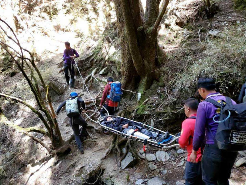 消防救援人員先以人力揹負方式救出王姓男子。（圖／南投縣消防局提供）