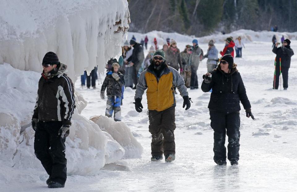 In this Feb. 2, 2014 photo people visit the caves at Apostle Islands National Lakeshore in northern Wisconsin, transformed into a dazzling display of ice sculptures by the arctic siege gripping the Upper Midwest. The caves are usually are accessible only by water, but Lake Superior’s rock-solid ice cover is letting people walk to them for the first time since 2009. (AP Photo/Minneapolis Star Tribune, Brian Peterson) MANDATORY CREDIT; ST. PAUL PIONEER PRESS OUT; MAGS OUT; TWIN CITIES TV OUT