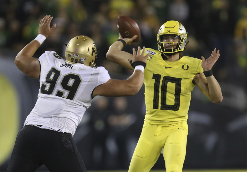 Colorado's Jalen Sami, left, rushes Oregon's Justin Herbert during the first quarter of an NCAA college football game Friday, Oct. 11, 2019, in Eugene, Ore. (AP Photo/Chris Pietsch)