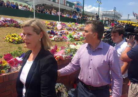 Chief Executive Deborah Thomas (L) of Australia's Ardent Leisure Group, the owner of Australia's biggest theme park where four people were killed on a water ride this week, and Dreamworld Chief Executive Craig Davidson walk past floral tributes outside the main entrance to Dreamworld on the Gold Coast, Australia, October 28, 2016. AAP/Ed Jackson/via REUTERS