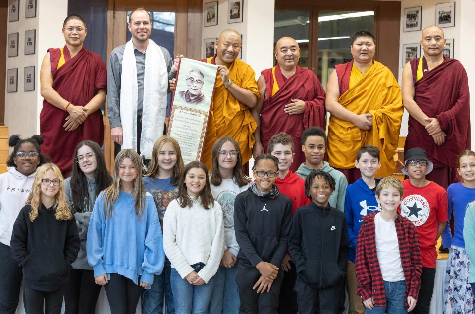 Tibetan monks visiting Canton pose for a photo with students after presenting a gift to the school that was accepted by Canton Country Day School's Business Manger Jeremy Hesson, top row second from left.
