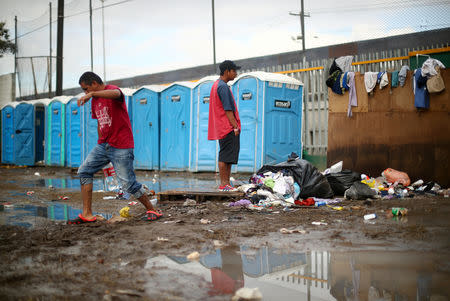 Migrants, part of a caravan of thousands from Central America trying to reach the United States, walk through a temporary shelter in Tijuana, Mexico, November 28, 2018. REUTERS/Hannah McKay