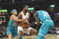 Cleveland Cavaliers' Evan Mobley, center, is tied up by Charlotte Hornets' Tre Mann (23) and JT Thor (21) during the first half of an NBA basketball game in Cleveland, Sunday, April 14, 2024. (AP Photo/Phil Long)