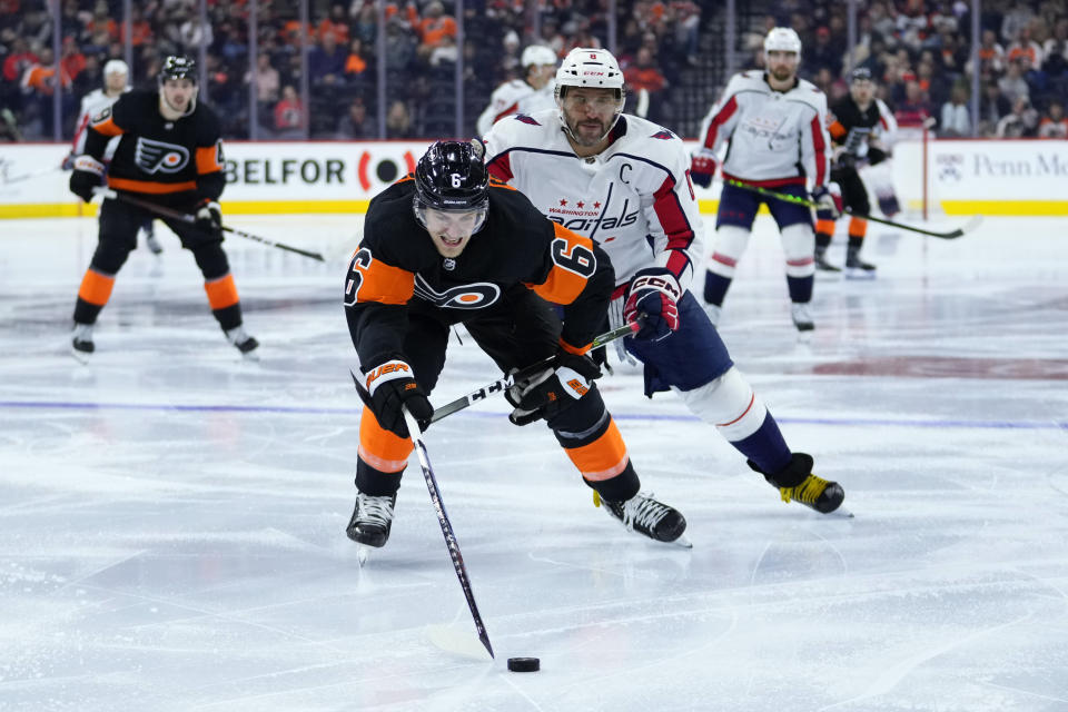 Philadelphia Flyers' Travis Sanheim, left, tries to keep the puck away from Washington Capitals' Alex Ovechkin during the third period of an NHL hockey game, Wednesday, Dec. 7, 2022, in Philadelphia. (AP Photo/Matt Slocum)