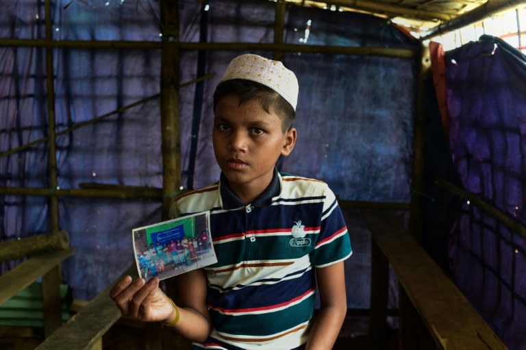 Mohammad Ayaz with a family photo showing around a dozen people of all ages posing for a portrait in Myanmar