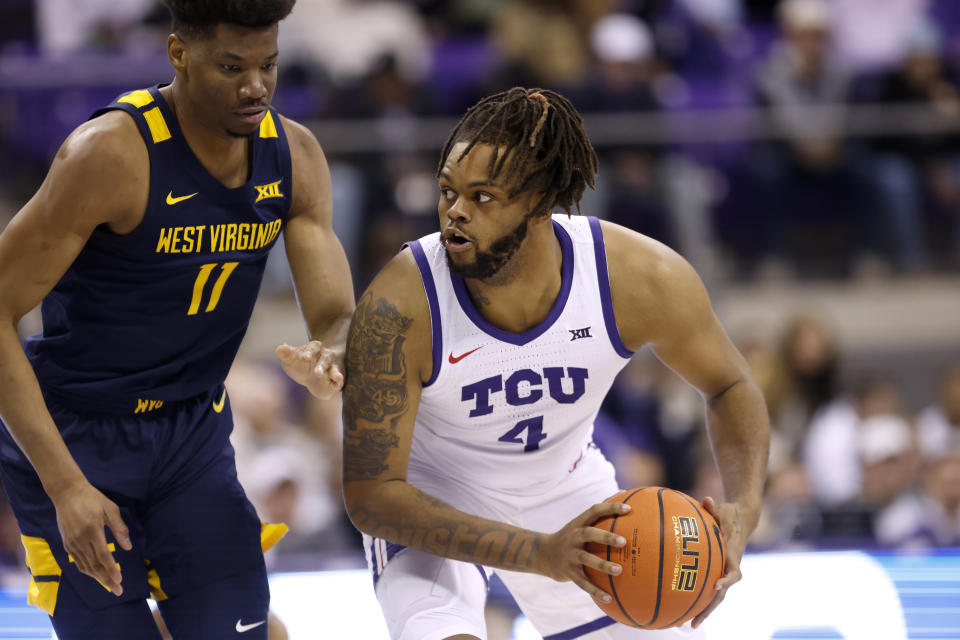 TCU center Eddie Lampkin Jr. (4) prepares to make a pass as West Virginia's Mohamed Wague (11) defends in the first half of an NCAA college basketball game, Tuesday, Jan. 31, 2023, in Fort Worth, Texas. (AP Photo/Ron Jenkins)