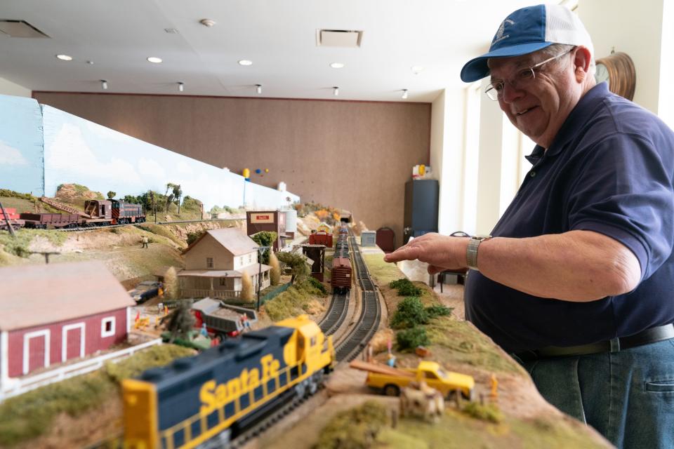 Stan Spice, treasurer of the Topeka Model Railroaders, makes sure the HO model trains on the club's layout keeps running Friday afternoon at the Fink Gallery of the Great Overland Station.