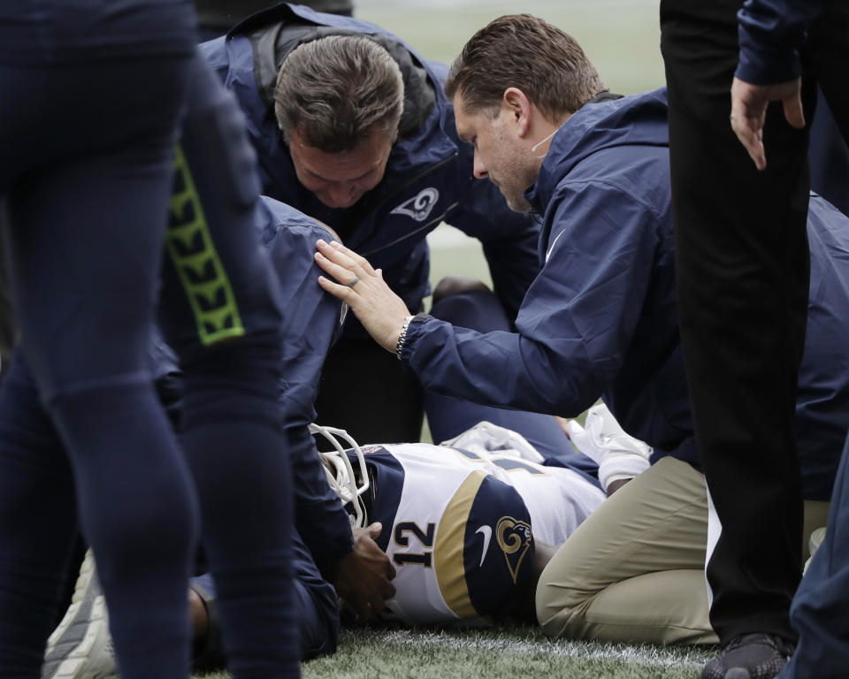 Los Angeles Rams wide receiver Brandin Cooks (12) is tended to on the field after he was injured during the first half of an NFL football game against the Seattle Seahawks, Sunday, Oct. 7, 2018, in Seattle. Cooks left the game with an injury. (AP Photo/Elaine Thompson)