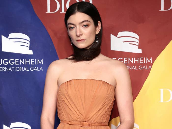 Lorde ties her hair around her neck while attending an event