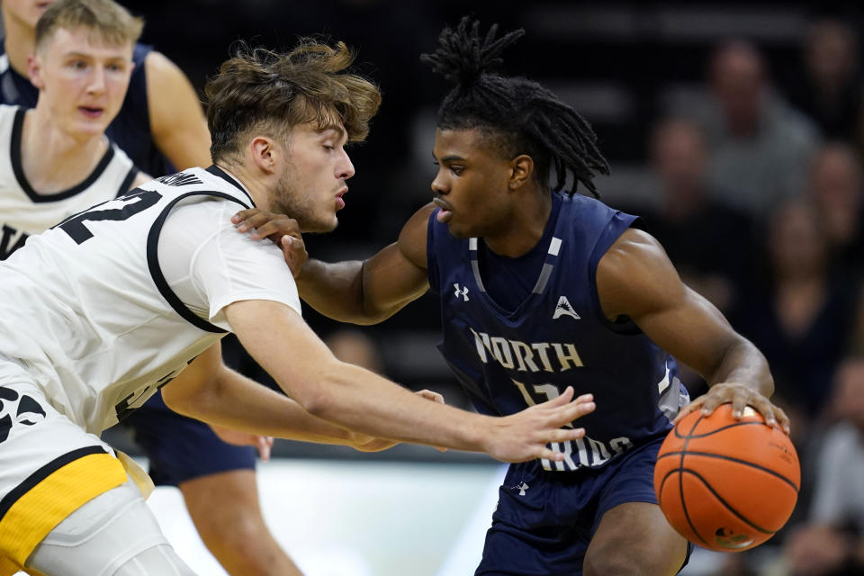 Iowa forward Owen Freeman tries to steal the ball from North Florida guard Jaylen Smith, right, during the second half of an NCAA college basketball game, Wednesday, Nov. 29, 2023, in Iowa City, Iowa. Iowa won 103-78. (AP Photo/Charlie Neibergall)