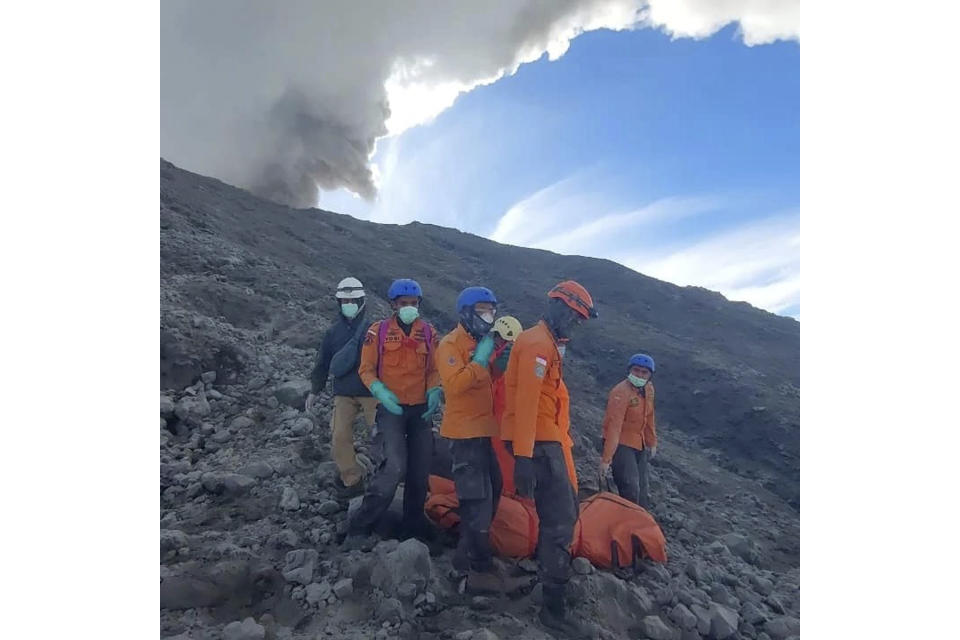 In this undated photo released Dec. 5, 2023, by the Indonesian National Search and Rescue Agency (BASARNAS), rescuers evacuate the body of a climber killed in Mount Marapi's eruption in Agam, West Sumatra, Indonesia. Rescuers searching the hazardous slopes of Indonesia's Marapi volcano found more bodies among the climbers caught by a surprise eruption two days ago. (BASARNAS via AP)