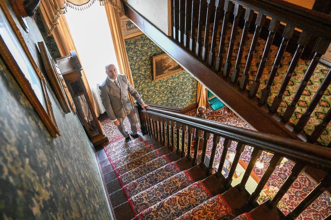 Meux Home Museum president and curator Quintin Hoskins stands at the base of the stairs that lead to the second floor bedrooms of the Meux home on Friday, April 26, 2024. CRAIG KOHLRUSS/ckohlruss@fresnobee.com