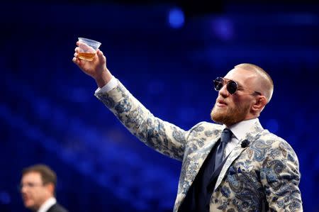 FILE PHOTO - UFC lightweight champion Conor McGregor of Ireland raises a cup of Irish whiskey during post-fight news conference at T-Mobile Arena in Las Vegas, Nevada, U.S. August 27, 2017. REUTERS/Steve Marcus