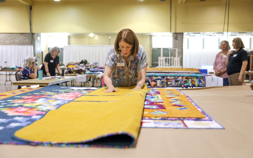 Kathie Kerler with the National Association Certified Quilt Judges examines a quilt Monday that she’s judging at the Oregon State Fair.