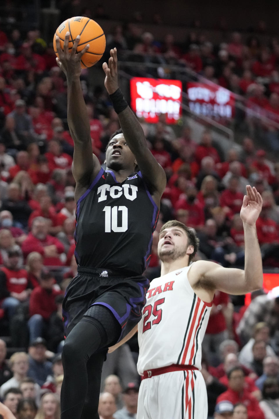 TCU guard Damion Baugh (10) goes to the basket past Utah guard Rollie Worster (25) during the first half of an NCAA college basketball game Wednesday, Dec. 21, 2022, in Salt Lake City. (AP Photo/Rick Bowmer)