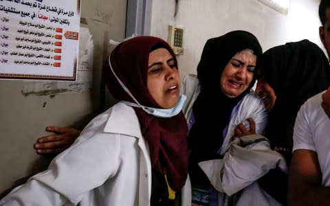 Palestinian paramedics mourn over the death of their colleague Razan al-Najjar i - Credit: SAID KHATIB/AFP/Getty Images