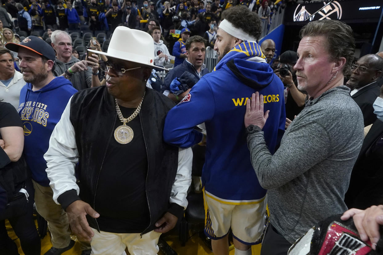 Golden State Warriors guard Klay Thompson, middle, walks past musician E-40, left, after Game 2 of an NBA basketball first-round playoff series between the Warriors and the Denver Nuggets in San Francisco, Monday, April 18, 2022. (AP Photo/Jeff Chiu)