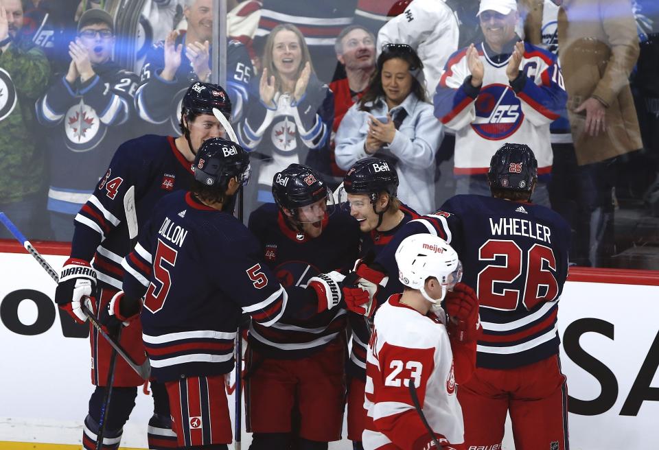 Winnipeg Jets' Logan Stanley (64), Brenden Dillon (5), Nikolaj Ehlers (27), Vladislav Namestnikov (7) and Blake Wheeler (26) celebrate after Wheeler's goal against the Detroit Red Wings during first-period NHL hockey action in Winnipeg, Manitoba, Friday, March 31, 2023. (John Woods/The Canadian Press via AP)