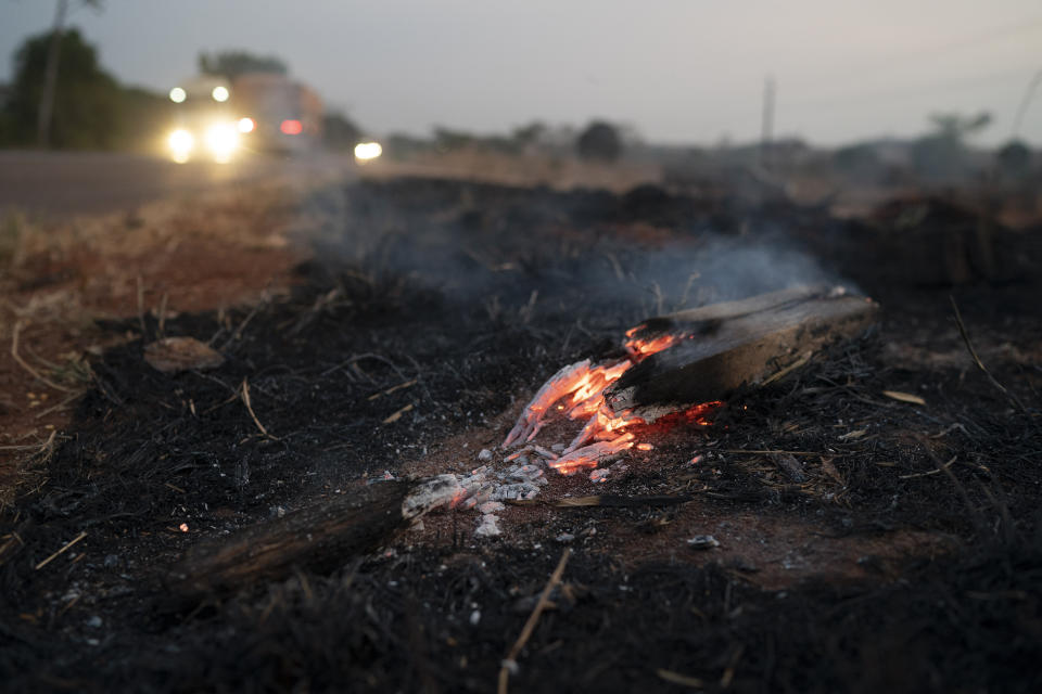 Embers from a wildfire smolder along BR 163 highway in the Nova Santa Helena municipality, in the state of Mato Grosso, Brazil, Friday, Aug. 23, 2019. Under increasing international pressure to contain fires sweeping parts of the Amazon, Brazilian President Jair Bolsonaro on Friday authorized use of the military to battle the massive blazes. (AP Photo/Leo Correa)