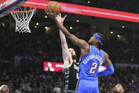 El base del Thunder de Oklahoma City Shai Gilgeous-Alexander lanza l balón frente a Sandro Mamukelashvili de los Spurs de San Antonio en el encuentro del miércoles 10 de abril del 2024. (AP Foto/Kyle Phillips)