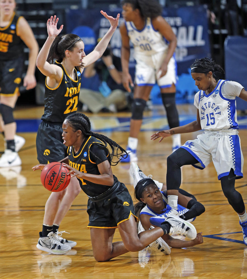 Iowa guard Tomi Taiwo (1) falls to the floor after being fouled by Kentucky guard Chasity Patterson (15) during the second half of a college basketball game in the second round of the women's NCAA tournament at the Greehey Arena in San Antonio, Tuesday, March 23, 2021. Iowa defeated Kentucky 86-72. (AP Photo/Ronald Cortes)