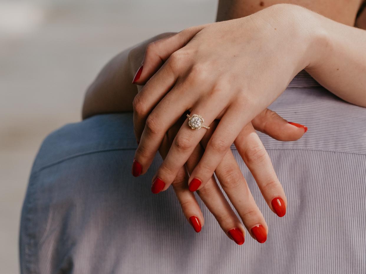 Woman with red nails hugs man