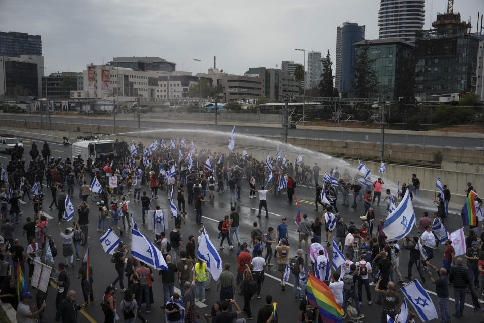 Israeli police use a water cannon to disperse Israelis blocking the freeway during a protest against plans by Prime Minister Benjamin Netanyahu's government to overhaul the judicial system in Tel Aviv, Israel, Thursday, March 23, 2023. (AP Photo/Oded Balilty)