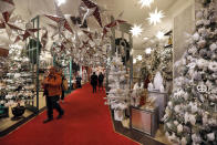 FILE - In this Tuesday, Nov. 5, 2019 file photo shoppers browse the Holiday Lane section at the Macy's flagship store, in New York. Macy’s cut its profit and sales expectations for the year after posting its first comparable store sales decline in almost two years, Thursday, Nov. 21. The company is citing the late arrival of colder weather, meager tourist business, weak traffic at some malls and problems on its website. (AP Photo/Richard Drew, File)