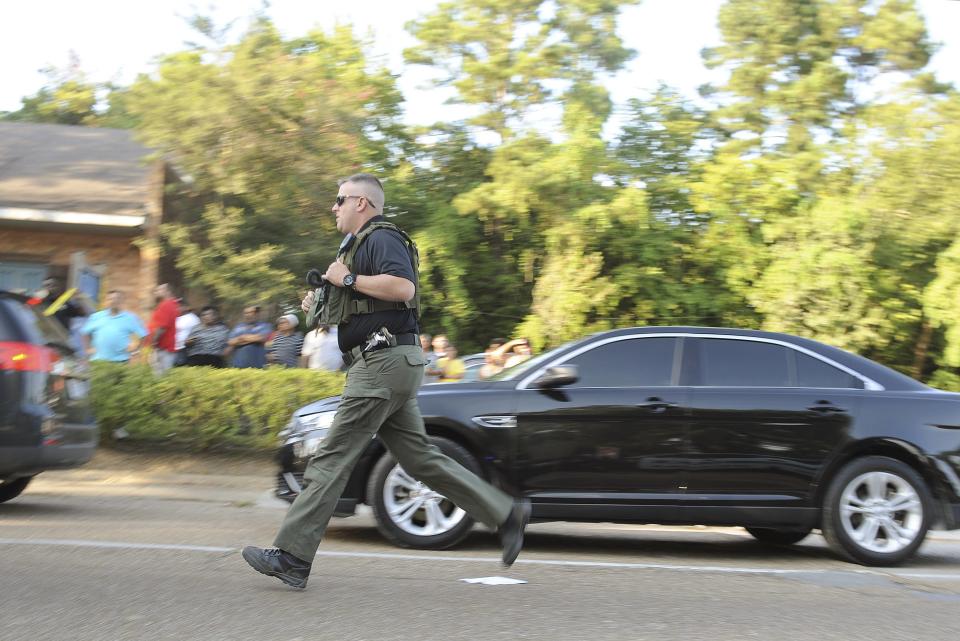 A police officer responds to a convenience store where a man entered with a gun barricaded himself against the police in Sunset Louisiana