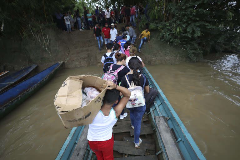 Venezolanos desembarcan de un bote Arauquita, Colombia