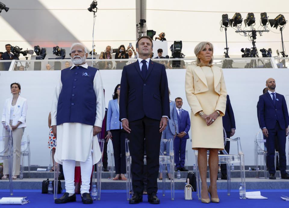 France's President Emmanuel Macron, center, his wife Brigitte Macron, right, and Indian Prime Minister Narendra Modi attend the annual Bastille Day military parade, in Paris, Friday, July 14, 2023. India is the guest of honor at this year's Bastille Day parade, with Prime Minister Narendra Modi in the presidential tribune alongside French President Emmanuel Macron. (Gonzalo Fuentes/Pool via AP)