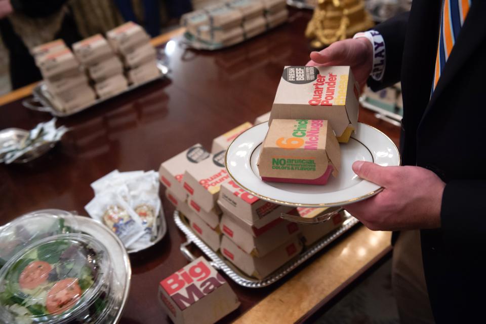 A guest selects fast food that the US president purchased for a ceremony honoring the 2018 College Football Playoff National Champion Clemson Tigers in the State Dining Room of the White House in Washington, DC, January 14, 2019. – US President Donald Trump says the White House chefs are furloughed due to the partial government shutdown. (Photo: Saul Loeb/AFP/Getty Images)