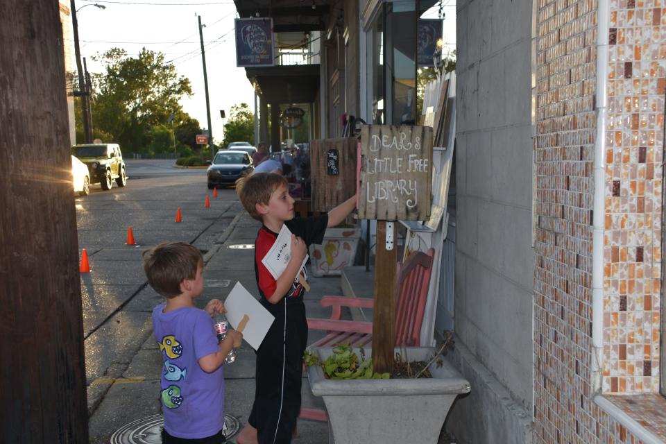 August Pierce, age 5, and Sawyer Pierce, age 8, look through a lending library in downtown Thibodaux during the Cajun Linen Night Aug. 11.