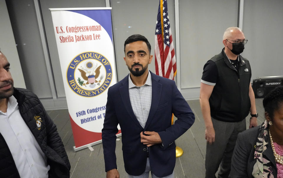 Abdul Wasi Safi adjusts his jacket after a news conference Friday, Jan. 27, 2023, in Houston. Wasi Safi, an intelligence officer for the Afghan National Security Forces who fled Afghanistan following the withdrawal of U.S. forces, was freed this week and reunited with his brother after spending months in immigration detention. (AP Photo/David J. Phillip)