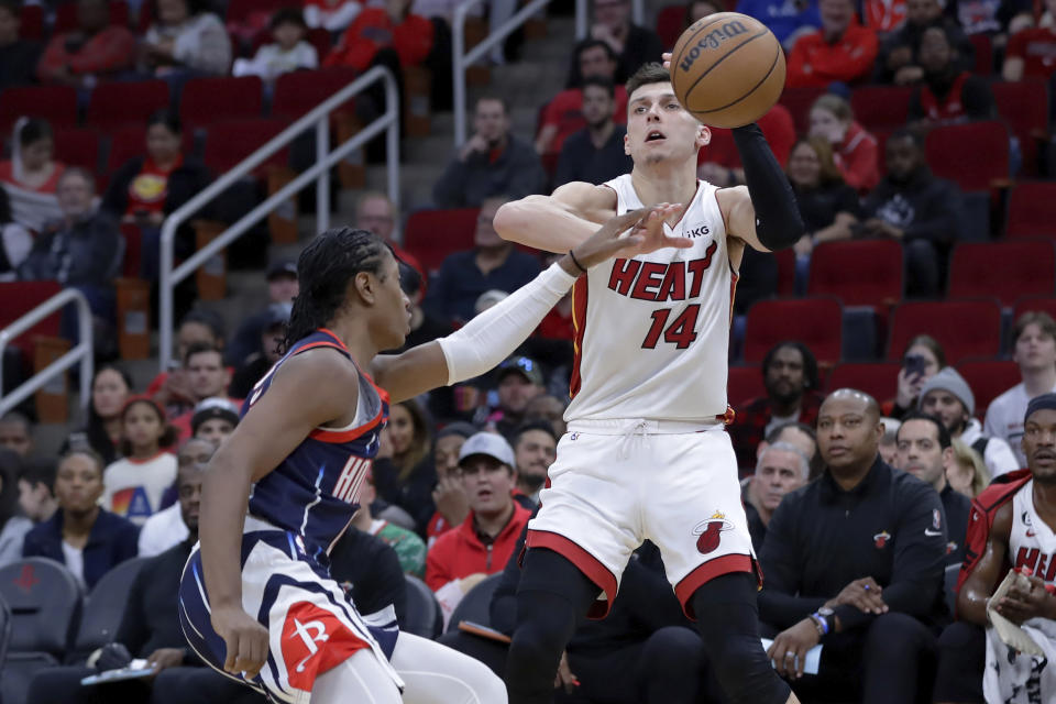 Houston Rockets guard TyTy Washington Jr., left, fouls Miami Heat guard Tyler Herro (14) as he attempts a shot during the first half of an NBA basketball game Thursday, Dec. 15, 2022, in Houston. (AP Photo/Michael Wyke)