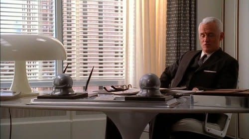 Roger Sterling's office is decked out with a white, mushroom-shaped table lamp and a slick white…