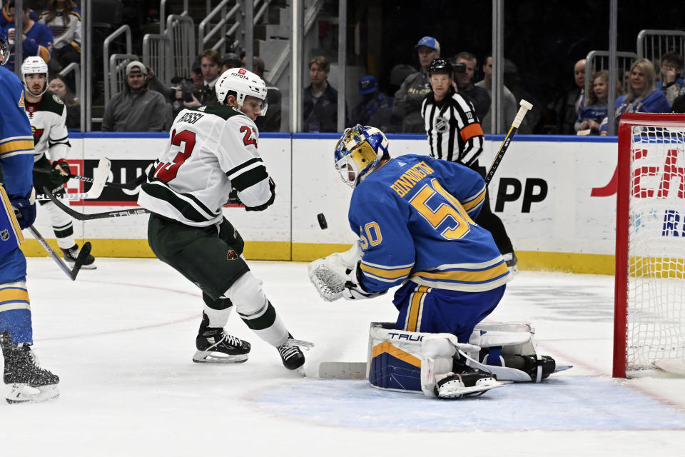 St. Louis Blues' Jordan Binnington (50) makes a save against Minnesota Wild Marco Rossi (23) during the first period of an NHL hockey game on Saturday, March 2, 2024, in St. Louis. (AP Photo/Michael Thomas)