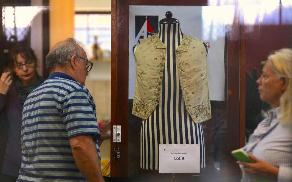 Potential buyers look at Captain Cook's waistcoat in Sydney - Credit: Reuters