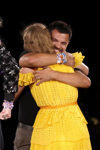 <p>Getty</p> Taylor Swift and Taylor Lautner embrace on stage during her Eras Tour