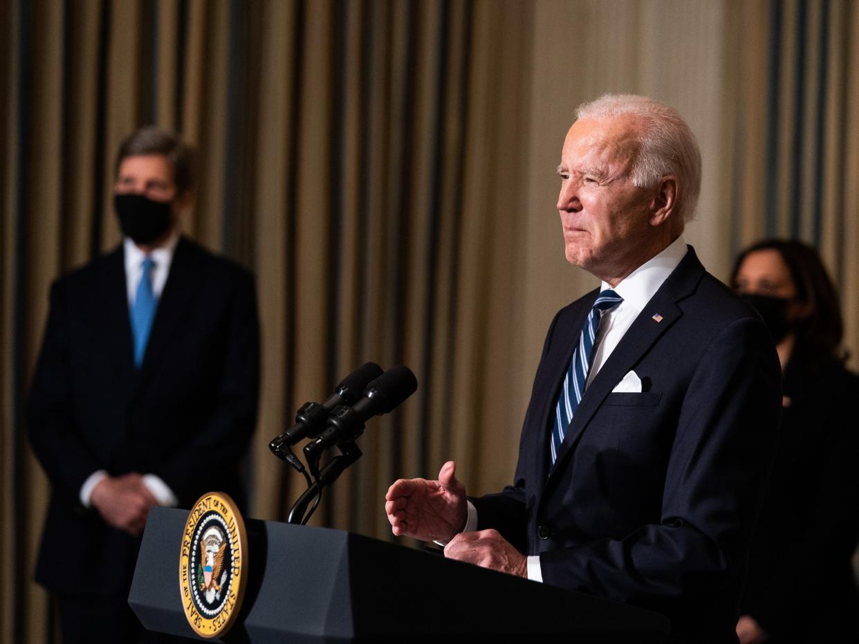  President Joe Biden delivers remarks on his administration’s response to climate change at the White House on 27 January, as VP Kamala Harris and special climate envoy John Kerry look on (EPA)